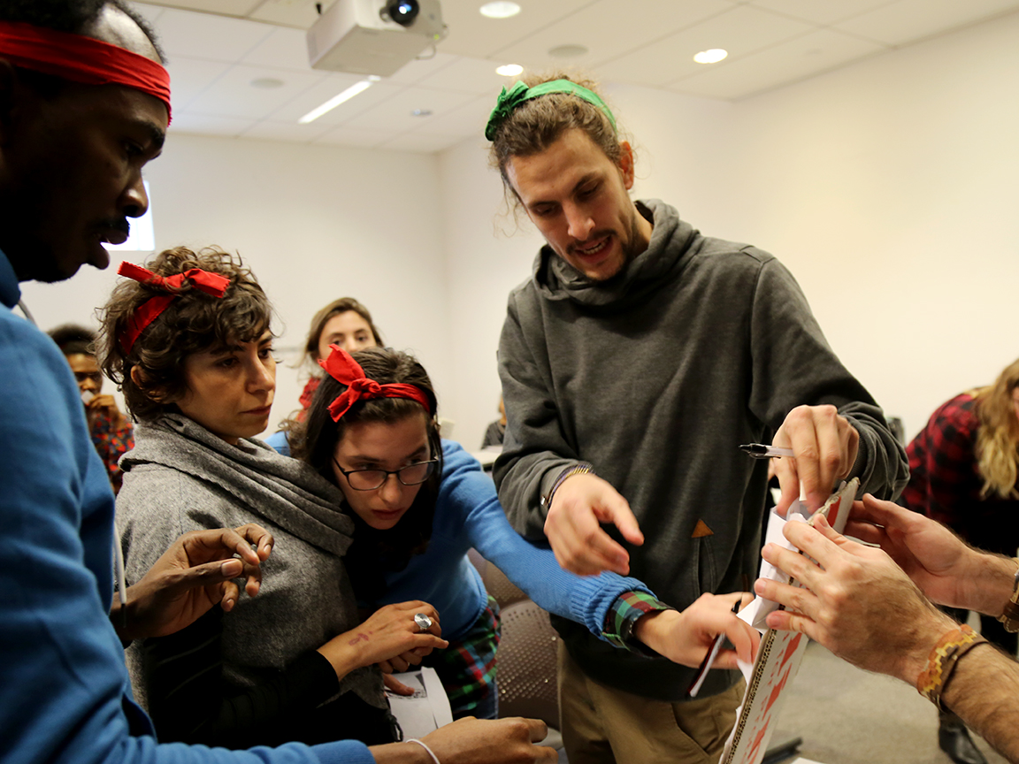 Students wearing green and red headbands work together.